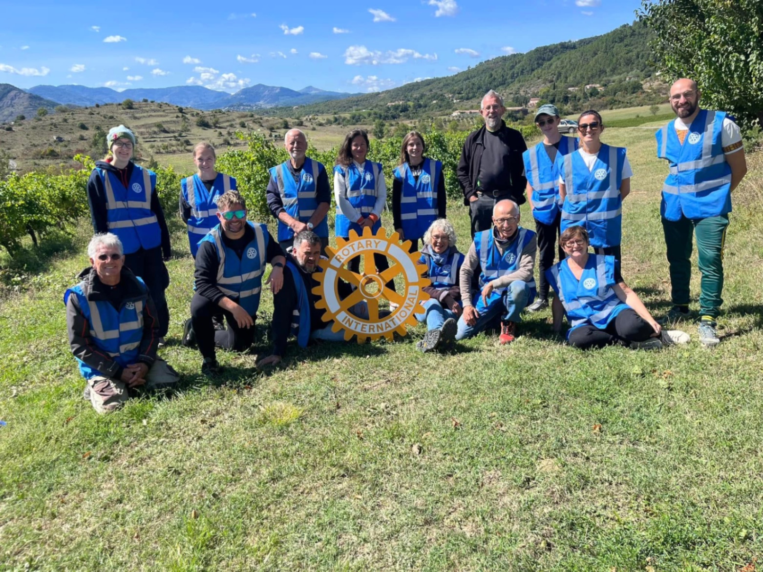 Membres du Rotary Club Privas Centre Ardèche en gilets bleus dans les vignes